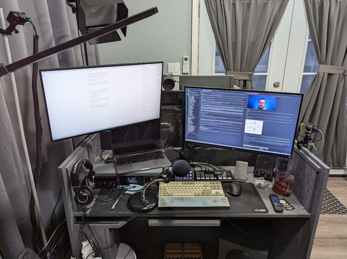 Picture of my desk that shows the three cameras I have, the two monitors, and the computers